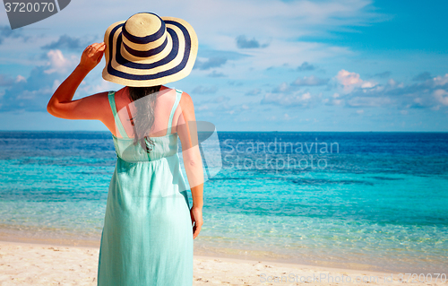 Image of Girl walking along a tropical beach in the Maldives.