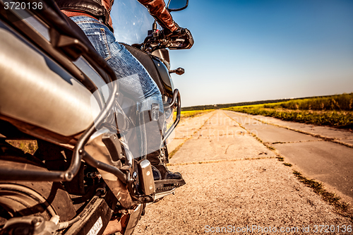 Image of Biker girl riding on a motorcycle