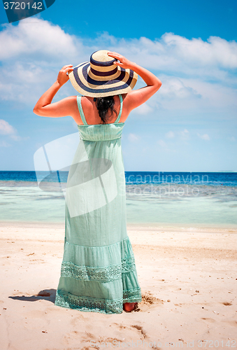 Image of Girl walking along a tropical beach in the Maldives.