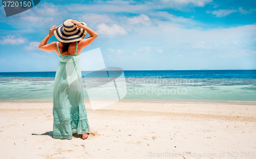 Image of Girl walking along a tropical beach in the Maldives.