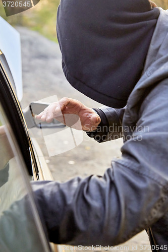 Image of Hooligan breaking into car