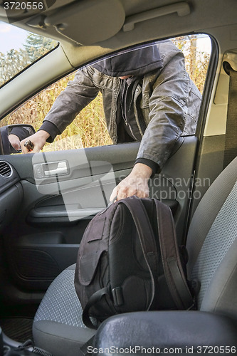 Image of Hooligan breaking into car