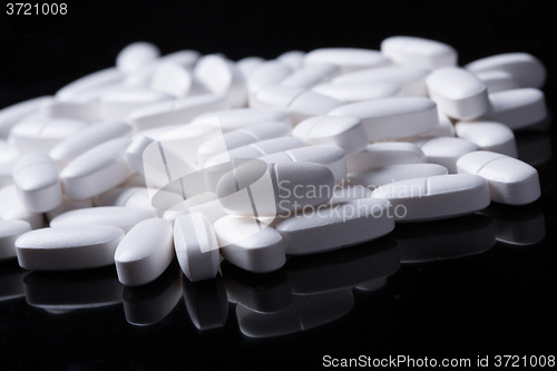 Image of White pills on the black