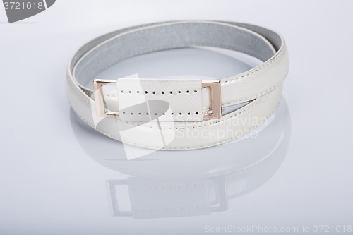 Image of thin white female belt buckle with fine