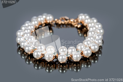 Image of bracelet of pearls on a gray background