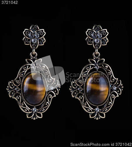 Image of bronze earrings with jewels on the black