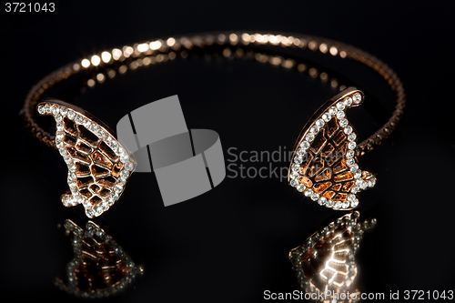 Image of gold bracelet on black background. 