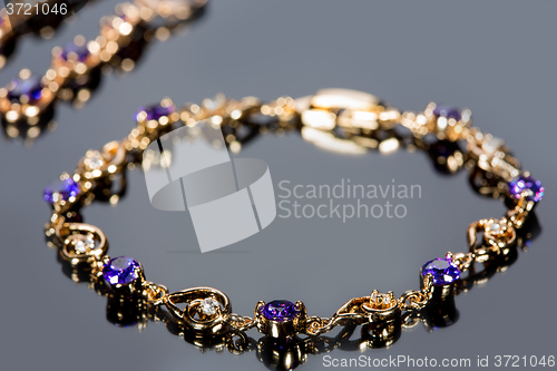 Image of gold bracelet on gray background. 