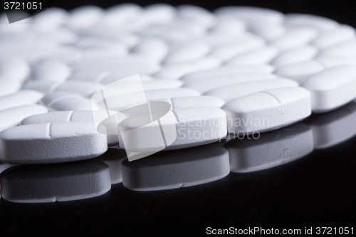 Image of White pills on the black