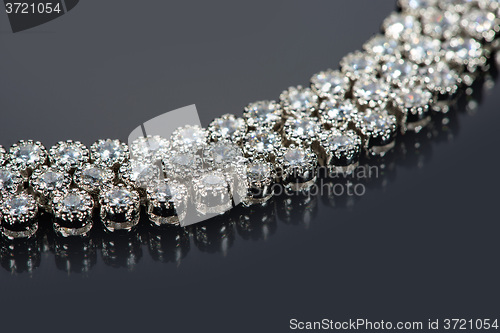 Image of golden bracelet with precious stones on grey background