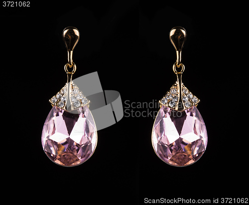 Image of earring with colorful pink gems on black background