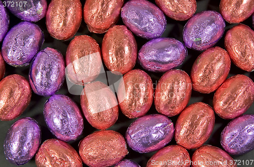 Image of collection of salmon pink and purple easter eggs as background