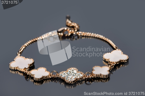 Image of gold bracelet on gray background. 