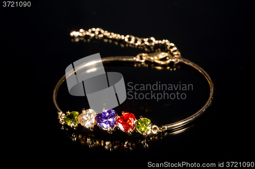 Image of gold bracelet on black background. 