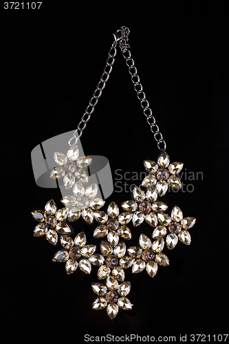 Image of luxury necklace of plastic flowers on black stand