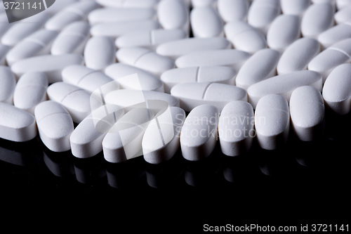 Image of White pills on the black