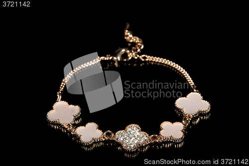 Image of gold bracelet on black background. 