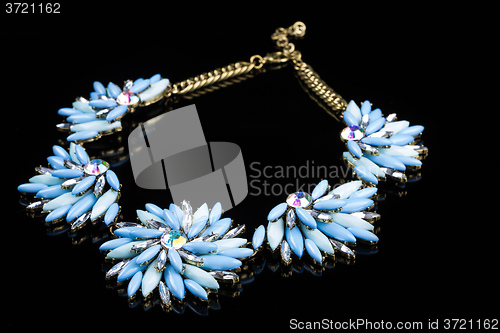 Image of luxury necklace of plastic flowers on black stand