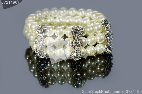 Image of bracelet of pearls on a gray background