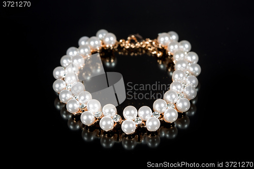 Image of bracelet of pearls on a black background