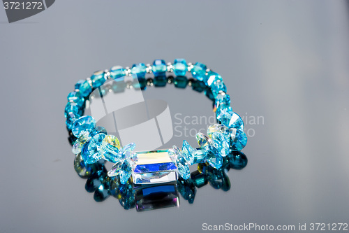 Image of beautiful blue bracelet on gray background. 