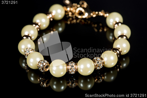 Image of bracelet of pearls on a black background