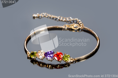 Image of gold bracelet on gray background. 