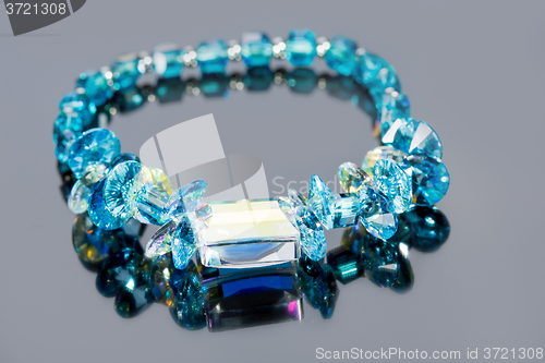 Image of beautiful blue bracelet on gray background. 