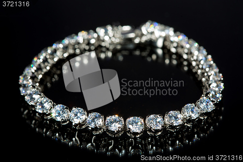 Image of golden bracelet with precious stones on black background