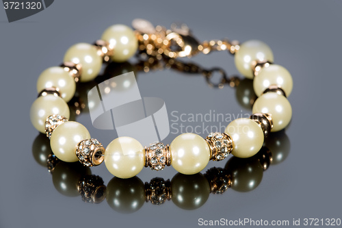 Image of bracelet of pearls on a gray background