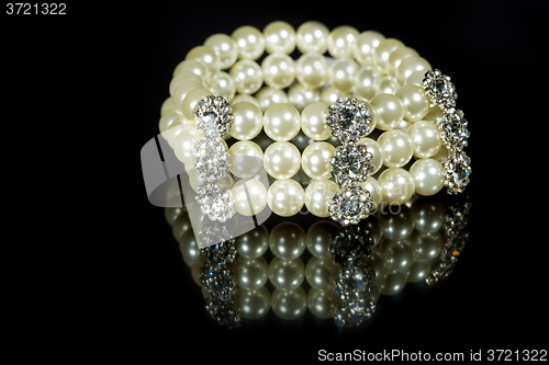 Image of bracelet of pearls on a black background