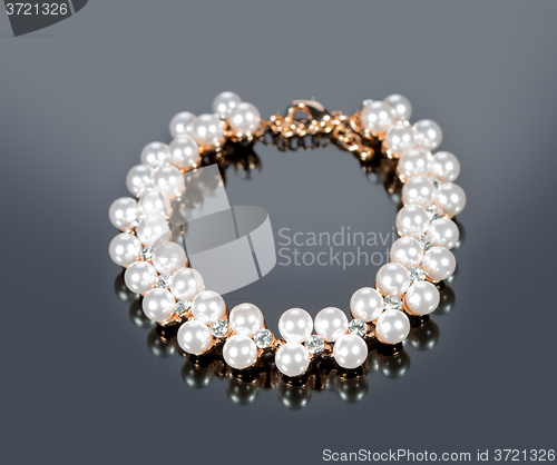 Image of bracelet of pearls on a gray background