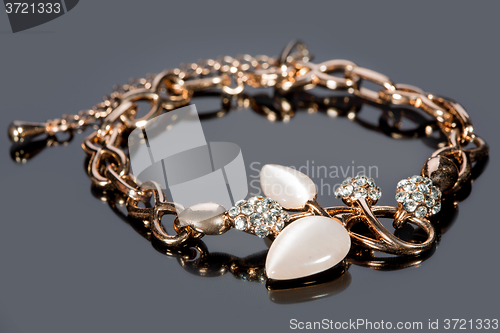 Image of gold bracelet on gray background. 