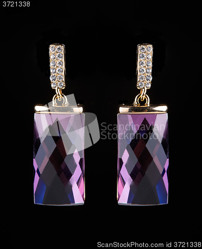 Image of earring with colorful pink gems on black background