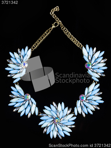 Image of luxury necklace of plastic flowers on black stand