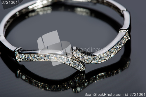 Image of golden bracelet with precious stones on grey background