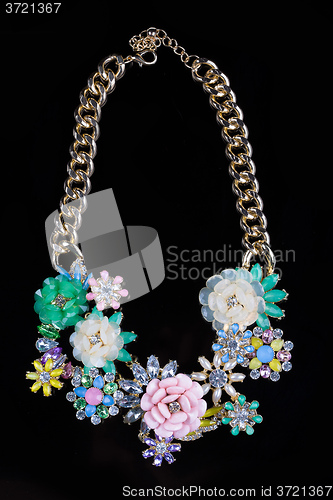 Image of luxury necklace of plastic flowers on black stand