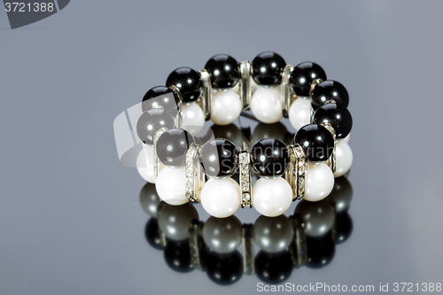 Image of bracelet of pearls on a gray background