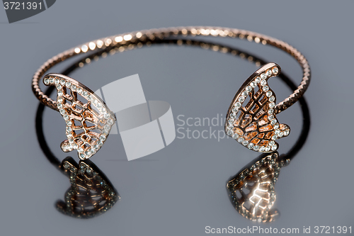 Image of gold bracelet on gray background. 