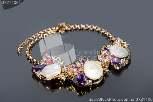 Image of gold bracelet on gray background. 