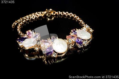 Image of gold bracelet on black background. 