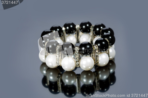 Image of bracelet of pearls on a gray background