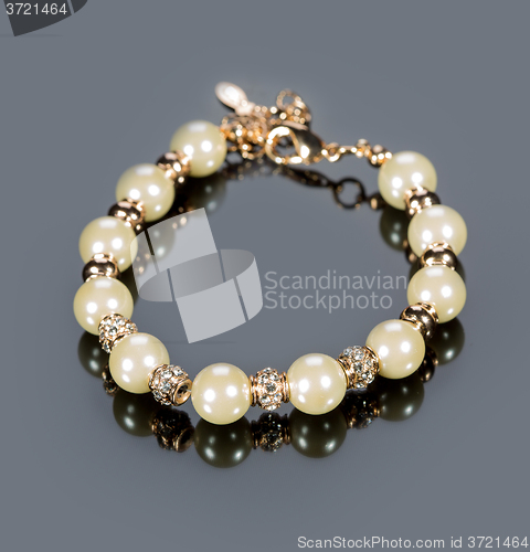 Image of bracelet of pearls on a gray background