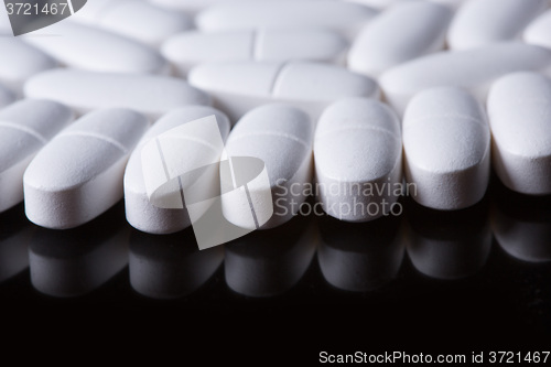 Image of White pills on the black