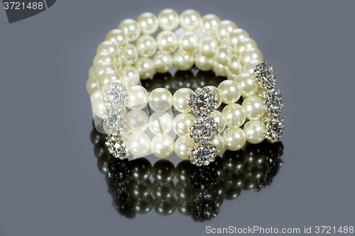 Image of bracelet of pearls on a gray background