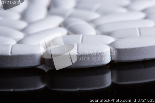 Image of White pills on the black