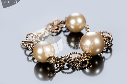 Image of bracelet of pearls on a gray background