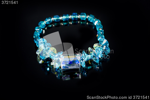 Image of beautiful blue plastic bracelet on black background. 
