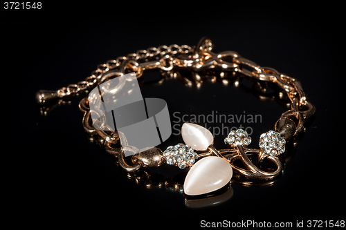 Image of gold bracelet on black background. 