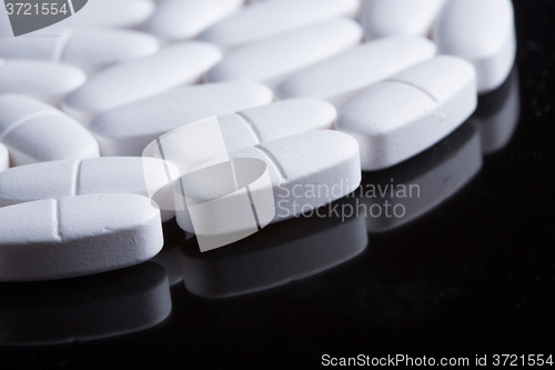 Image of White pills on the black